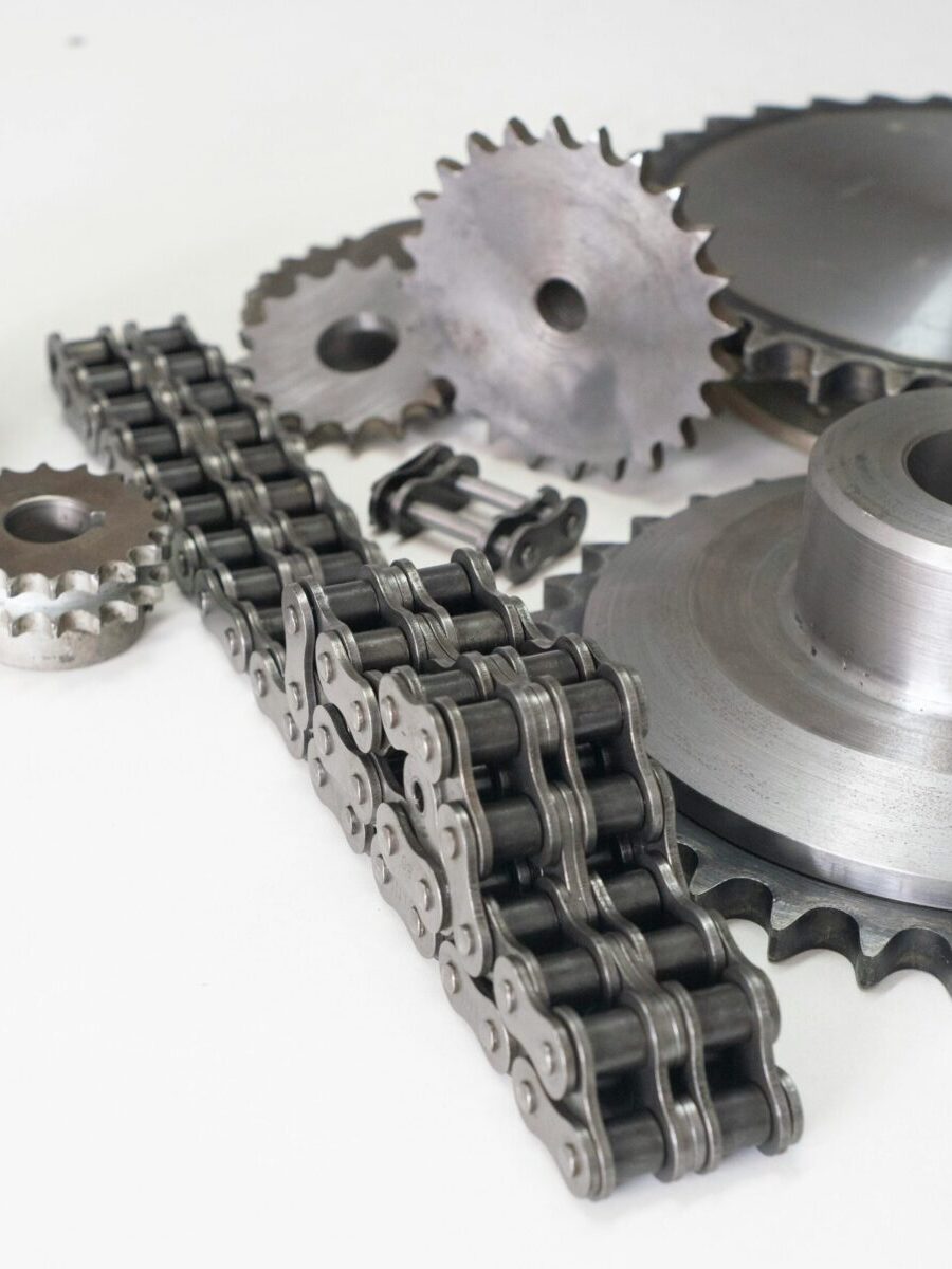 Detailed close-up of motorcycle mechanical gear parts and chains on a white background.