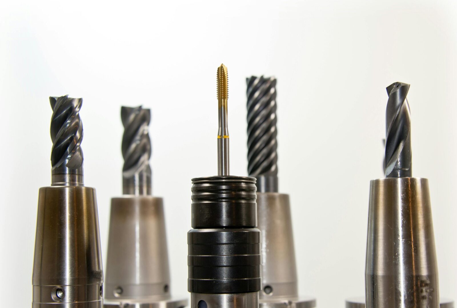 A close-up view of metal drill bits arranged vertically, showcasing industrial tools.